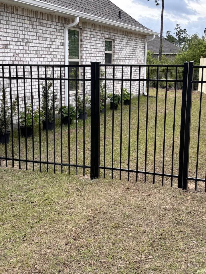 Black aluminum fence at brick home